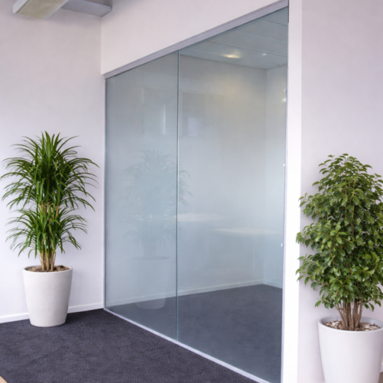 Moderni toimiston lasiseinä kirkkaasta karkaistusta lasista